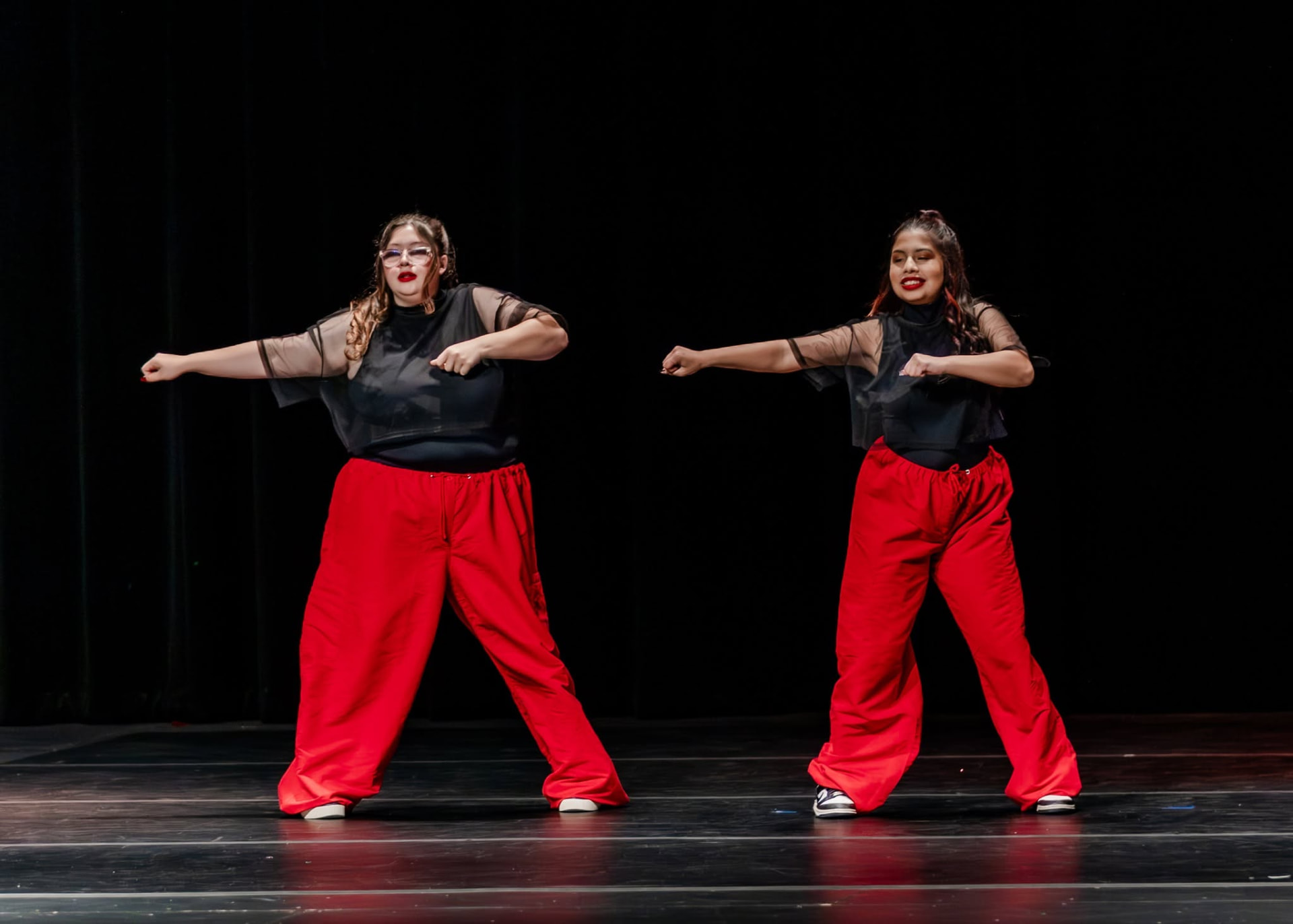 Two hip hop dancers in red pants performing on stage