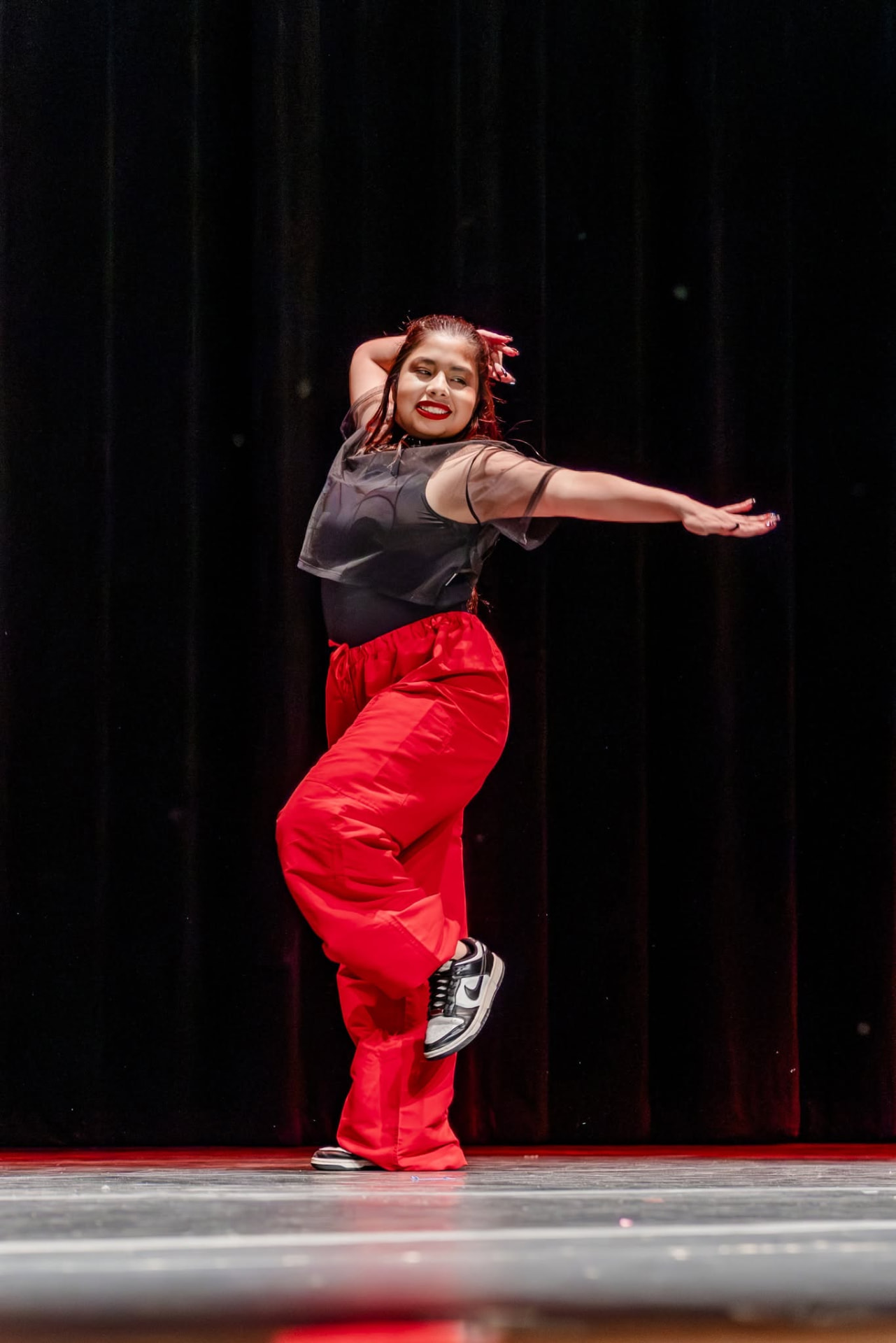 Hip hop dancer in red pants posing on stage