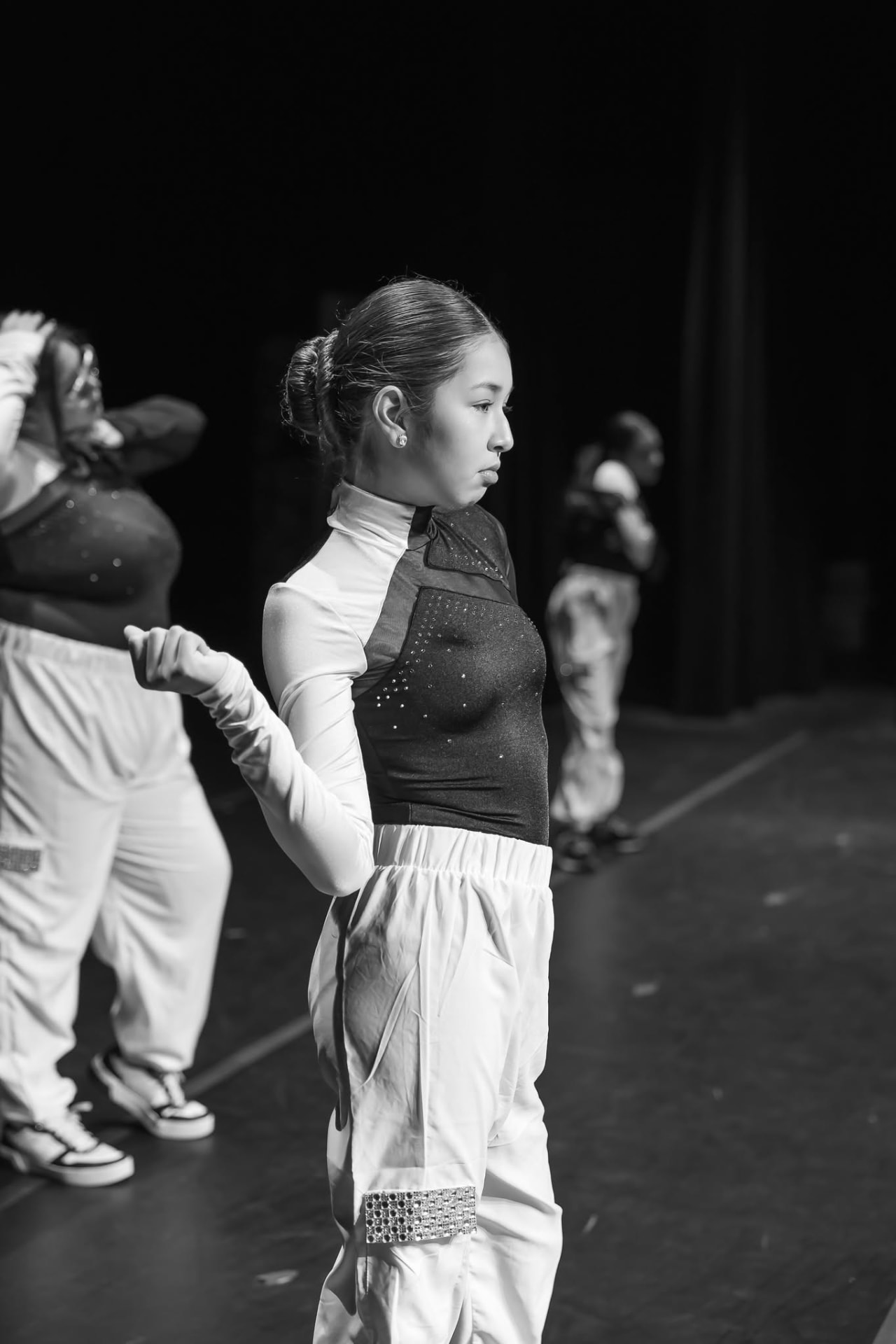 Hip hop dancer in white pants on stage in black and white