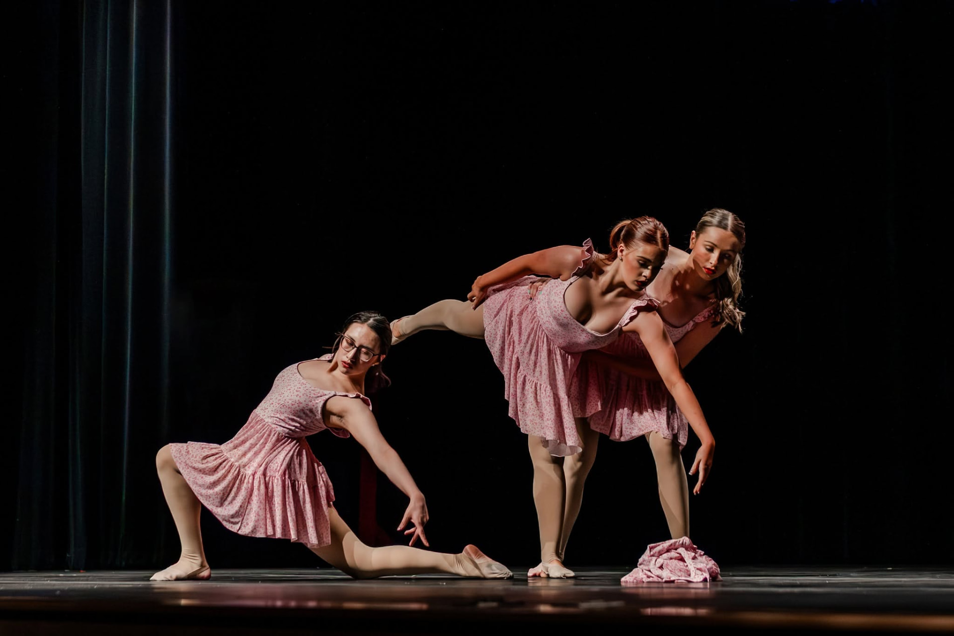 Three dancers in pink dresses in a contemporary trio