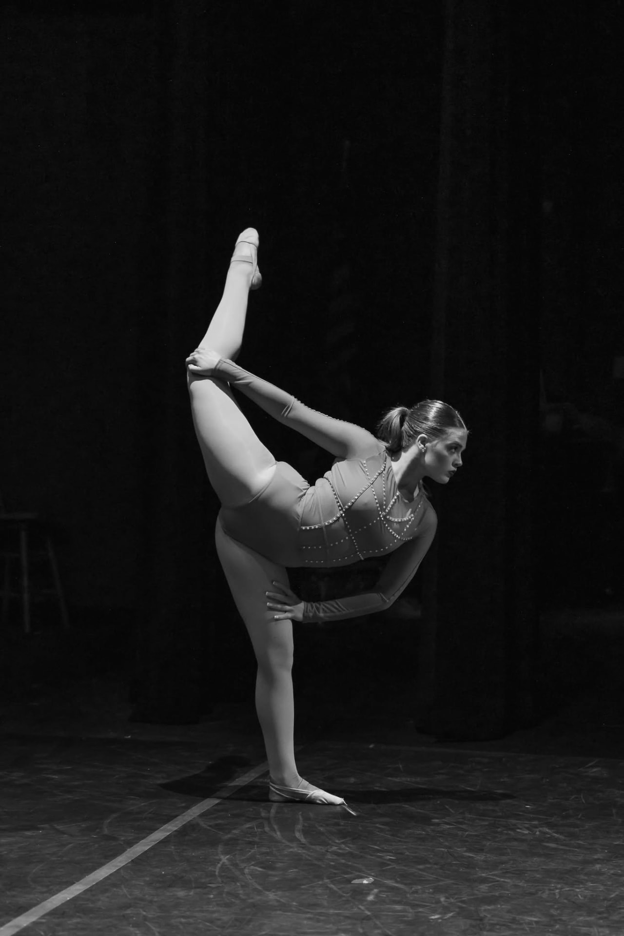 Senior dancer holding a standing split on stage